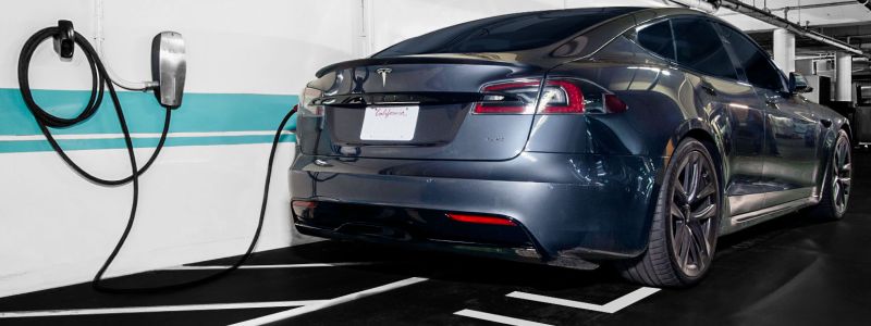 A TESLA plugged into a charging station at the Sunset Marquis in their Electric Vehicle garage.